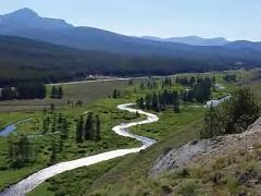 View of the Sawtooth Valley with a river, wetlands, and forest covered hills.