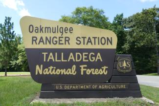 Oakmulgee Ranger Station Talladega National Forest in yellow and brown text  
